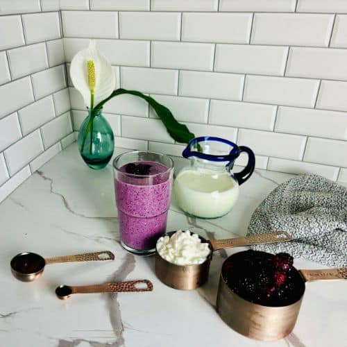Ingredients for a berry cottage cheese smoothie: cottage cheese, milk, frozen mixed berries, maple syrup, and vanilla extract.